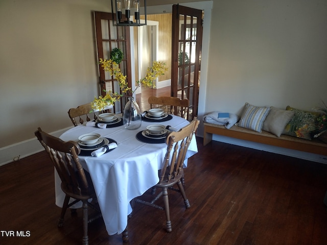 dining area with dark hardwood / wood-style flooring and a chandelier