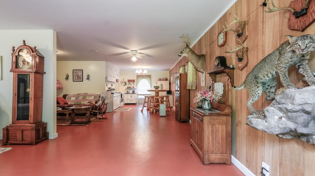 interior space featuring ceiling fan with notable chandelier