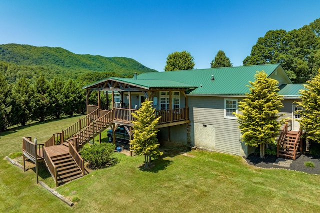 back of property with a wooden deck and a yard