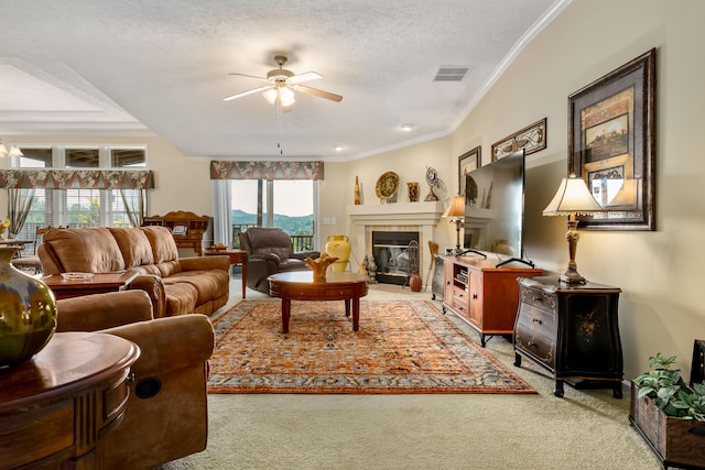 carpeted living room featuring a healthy amount of sunlight, ceiling fan, a textured ceiling, and a tiled fireplace