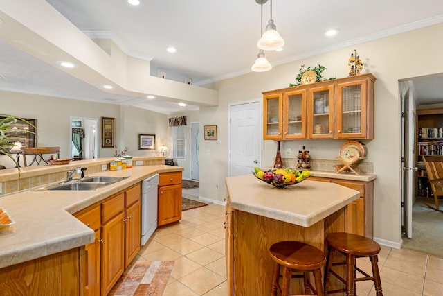 kitchen featuring white dishwasher, light tile floors, a kitchen island, a breakfast bar area, and sink