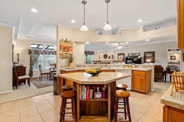 kitchen with a kitchen bar, ceiling fan, light tile floors, and dishwasher