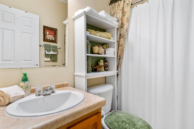 bathroom with toilet and vanity with extensive cabinet space