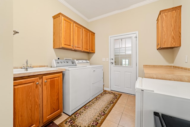 laundry area with independent washer and dryer, sink, ornamental molding, light tile flooring, and cabinets