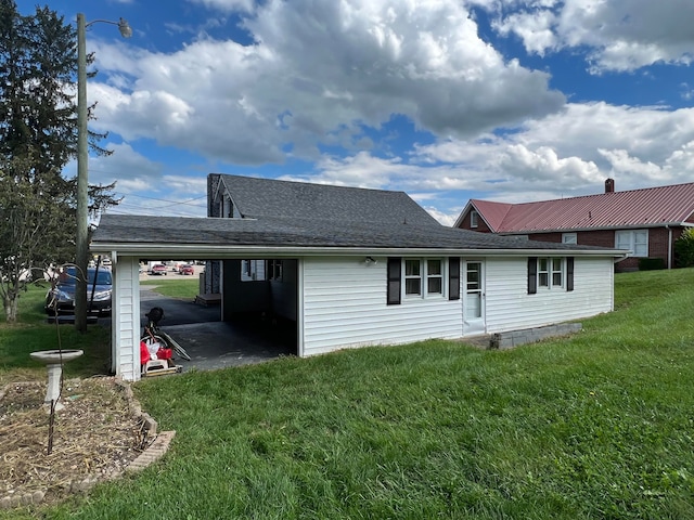 back of property featuring a carport and a yard