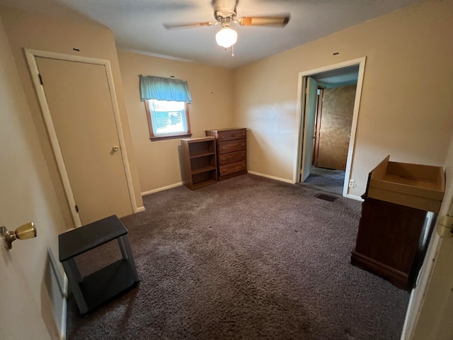 unfurnished bedroom featuring dark carpet and ceiling fan