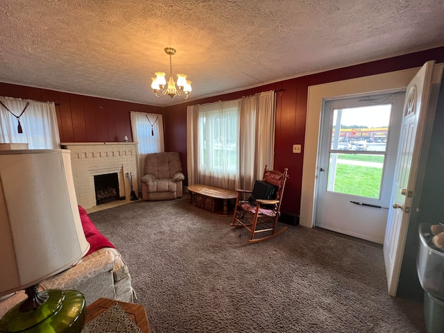 interior space with dark colored carpet, a brick fireplace, a notable chandelier, and a textured ceiling