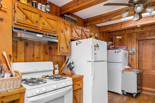 kitchen featuring white appliances, ceiling fan, wood walls, dark wood-type flooring, and beam ceiling