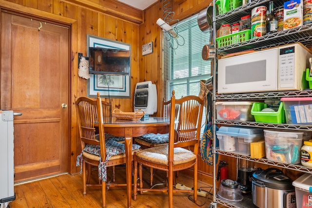 dining area featuring light hardwood / wood-style flooring and wood walls