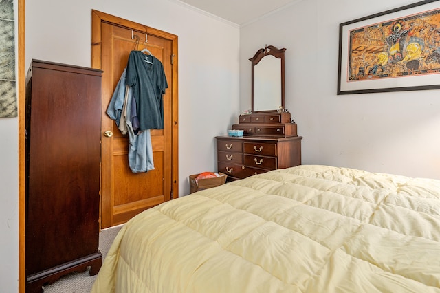 bedroom with ornamental molding and carpet