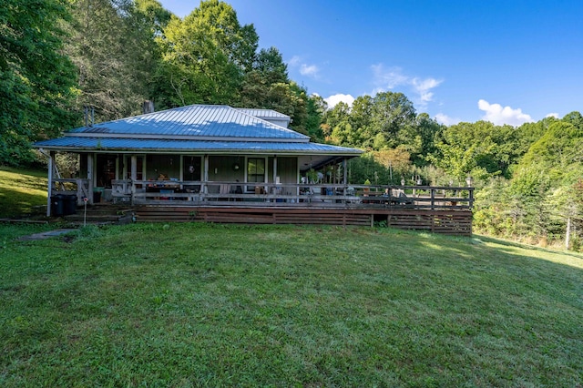 rear view of house featuring a yard and a porch