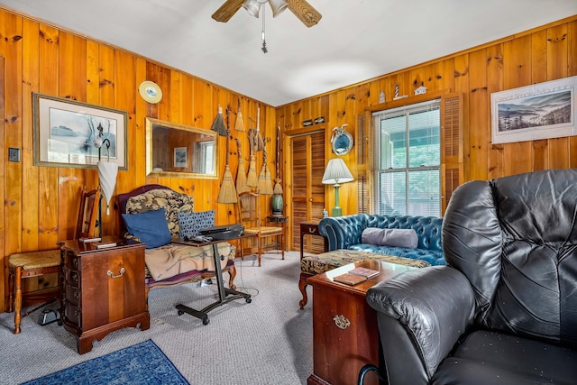 carpeted living room featuring ceiling fan and wooden walls