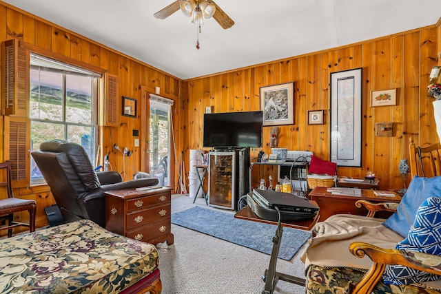 living room with light carpet, wood walls, and ceiling fan