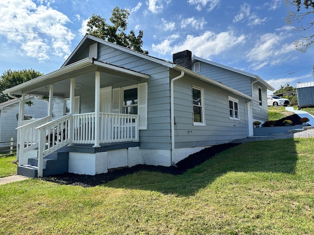 view of property exterior featuring covered porch and a yard