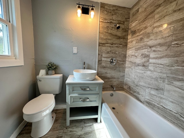 full bathroom featuring tile floors, tiled shower / bath, toilet, and vanity