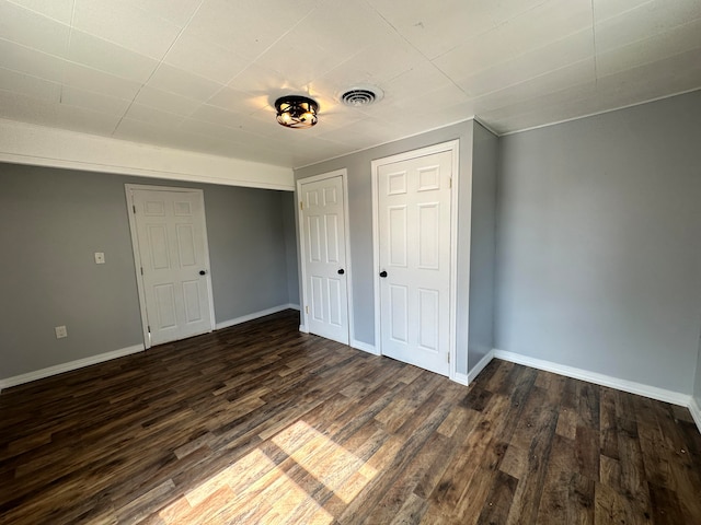 unfurnished bedroom with dark hardwood / wood-style flooring