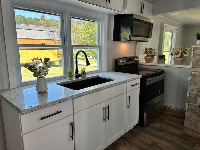 kitchen featuring light stone countertops, white cabinets, range with electric stovetop, plenty of natural light, and dark hardwood / wood-style flooring