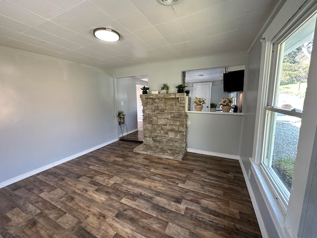 spare room featuring dark hardwood / wood-style floors and a healthy amount of sunlight