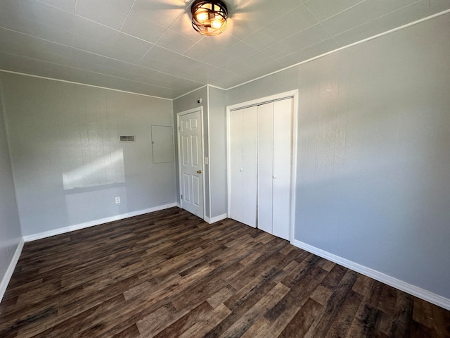 unfurnished bedroom with a closet and dark wood-type flooring