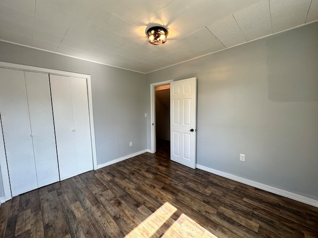 unfurnished bedroom featuring dark hardwood / wood-style floors and a closet