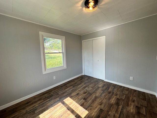 unfurnished bedroom featuring dark hardwood / wood-style floors and a closet