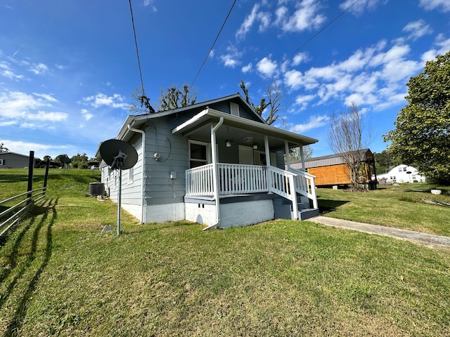 view of front facade featuring a front lawn, central AC, and a porch