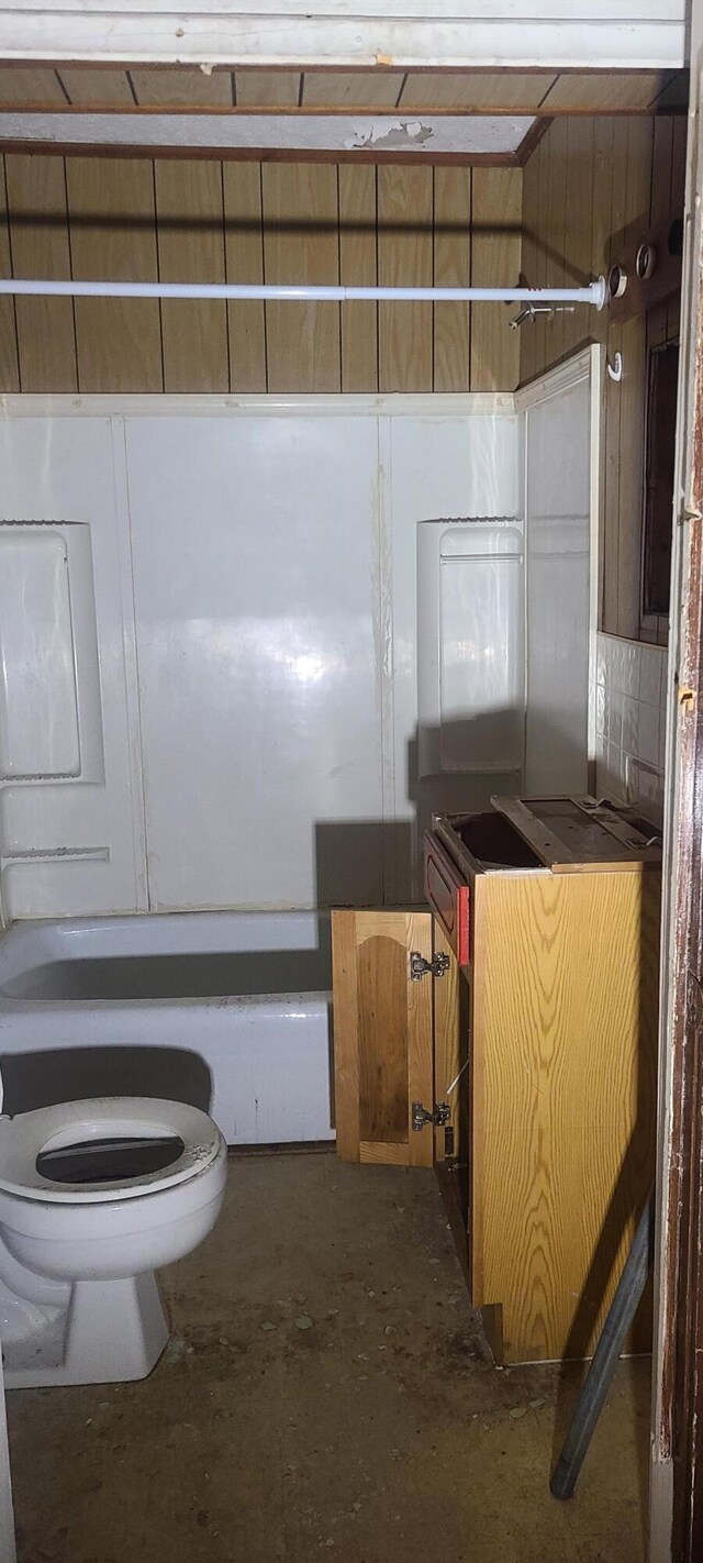 bathroom featuring  shower combination, toilet, and concrete flooring