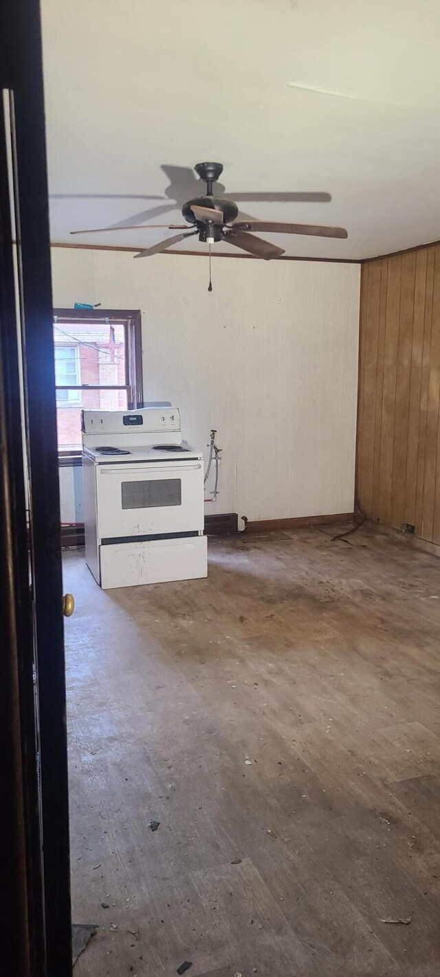 spare room featuring ceiling fan and wood walls