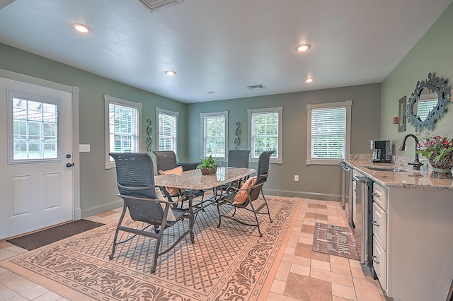 dining space with sink, a wealth of natural light, and light tile flooring