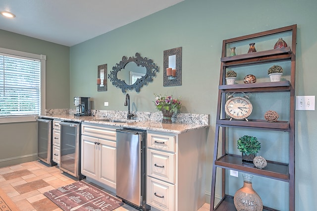 bar with white cabinetry, light tile floors, beverage cooler, light stone countertops, and sink