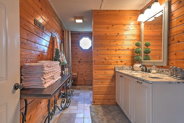 bathroom featuring wooden walls, large vanity, and tile floors