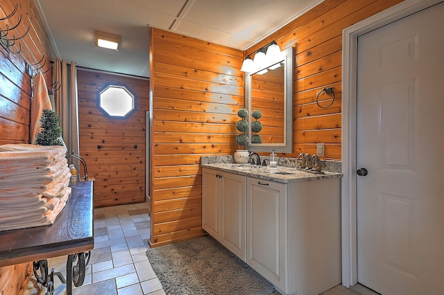 bathroom with tile flooring, vanity, and wood walls