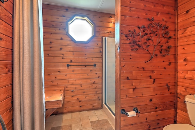 bathroom with tile floors, toilet, and wood walls