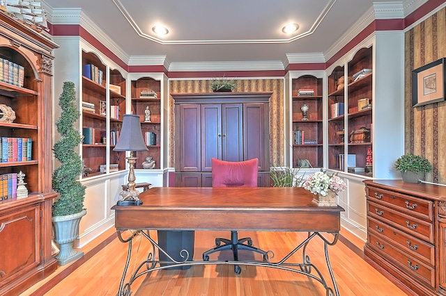 office space with light hardwood / wood-style flooring, crown molding, and built in shelves