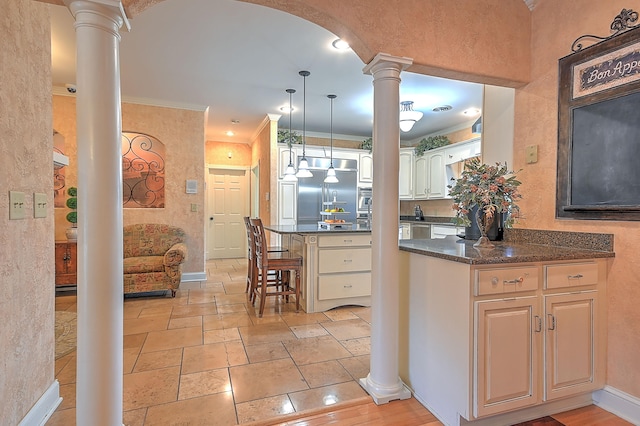 kitchen featuring crown molding, light tile flooring, ornate columns, stainless steel built in fridge, and hanging light fixtures