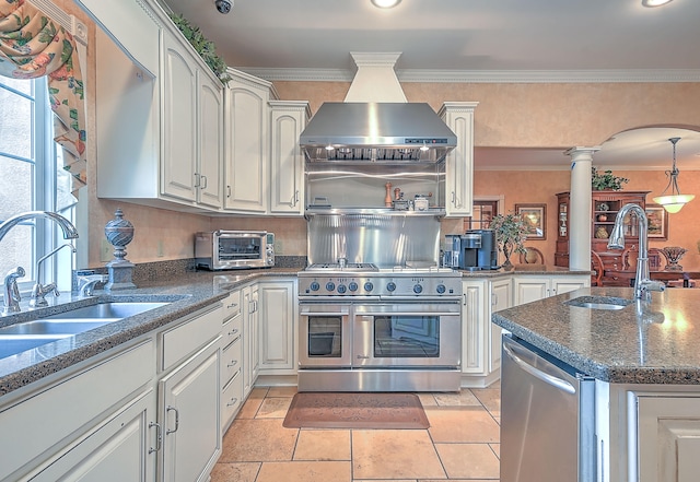 kitchen featuring light tile floors, appliances with stainless steel finishes, sink, white cabinetry, and ornate columns