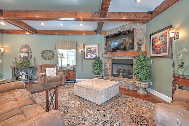 living room featuring beamed ceiling, dark hardwood / wood-style flooring, and a fireplace