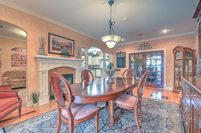 dining room with french doors, crown molding, and light hardwood / wood-style flooring