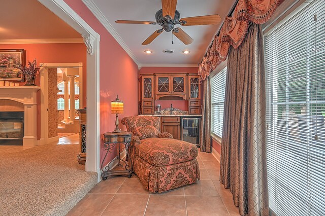 sitting room with crown molding, ceiling fan, and light carpet