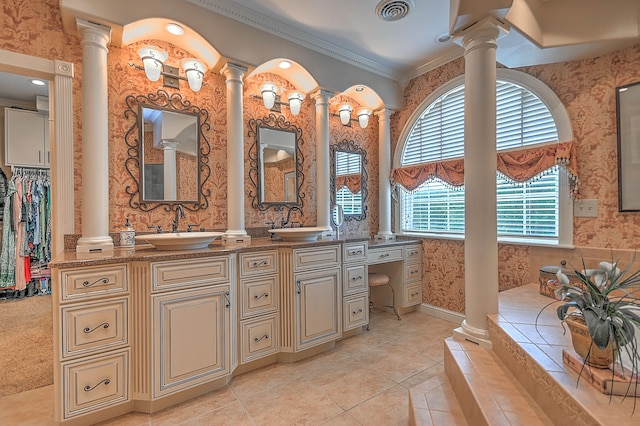 bathroom with crown molding, double vanity, tiled bath, decorative columns, and tile floors