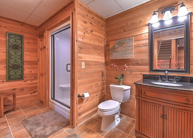 bathroom with tile floors, wooden walls, a paneled ceiling, toilet, and oversized vanity