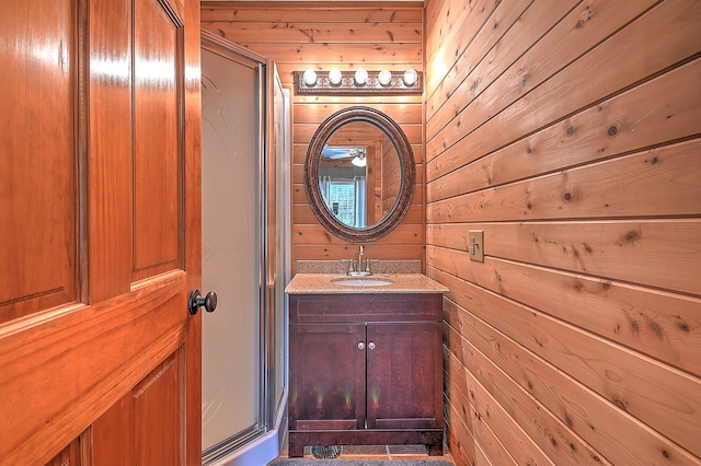 bathroom with wooden walls, oversized vanity, and walk in shower