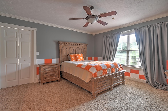 carpeted bedroom featuring ornamental molding, a textured ceiling, a closet, and ceiling fan