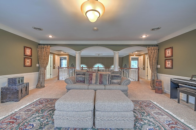 living room with crown molding, a wealth of natural light, and decorative columns