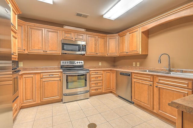 kitchen featuring sink, stainless steel appliances, and light tile flooring