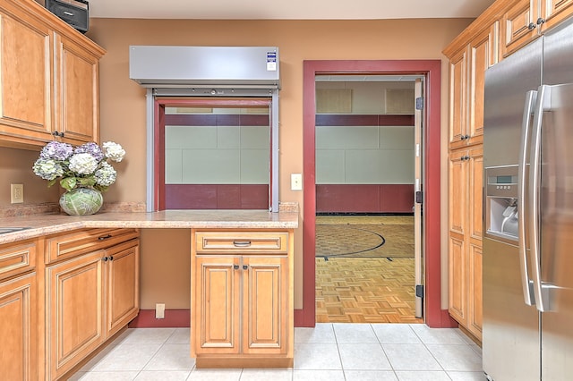 kitchen featuring light tile floors, light stone counters, and stainless steel refrigerator with ice dispenser