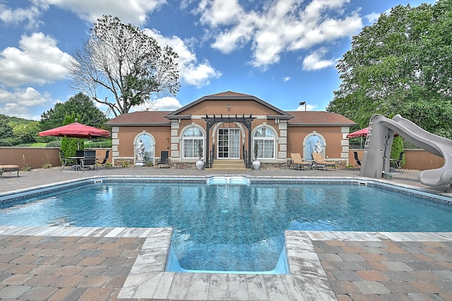 view of pool featuring a water slide and a patio