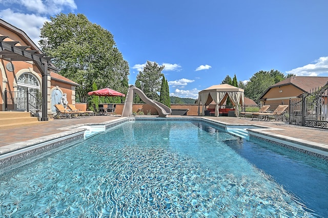 view of pool featuring a water slide and a patio area