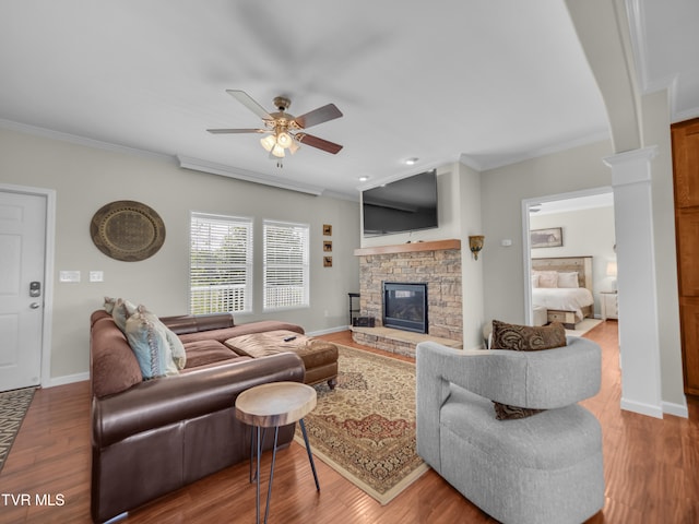 living room featuring a fireplace, ornamental molding, hardwood / wood-style flooring, and ceiling fan