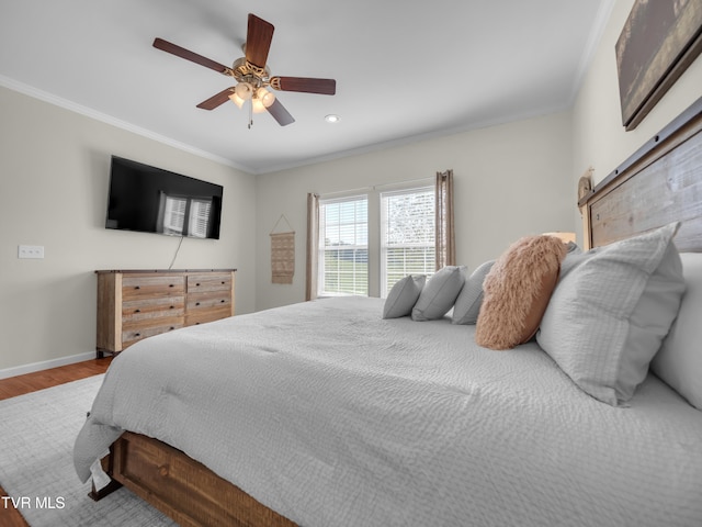 bedroom featuring crown molding, a barn door, ceiling fan, and light wood-type flooring